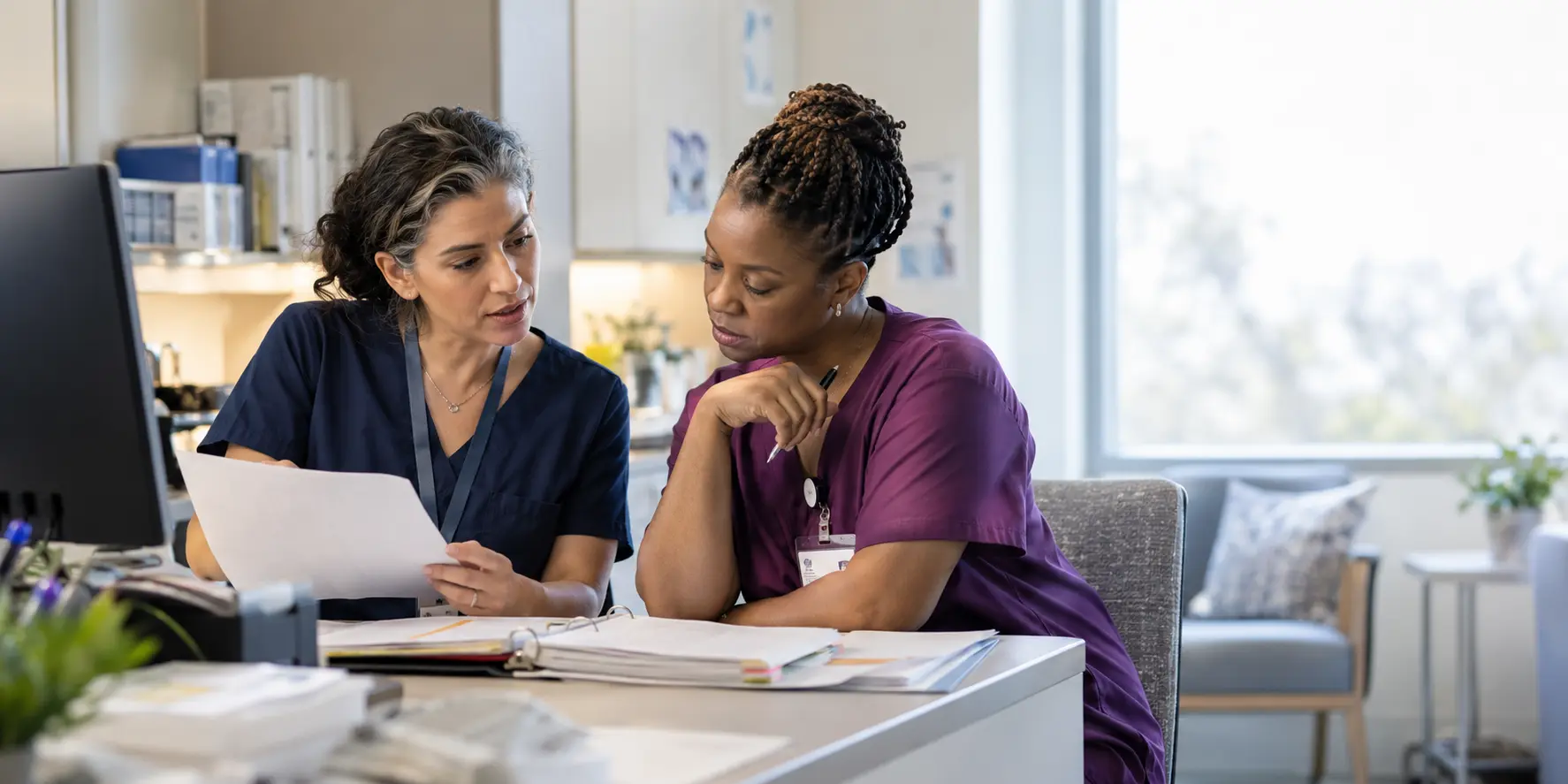 Two clinical research professionals reviewing study instructions together